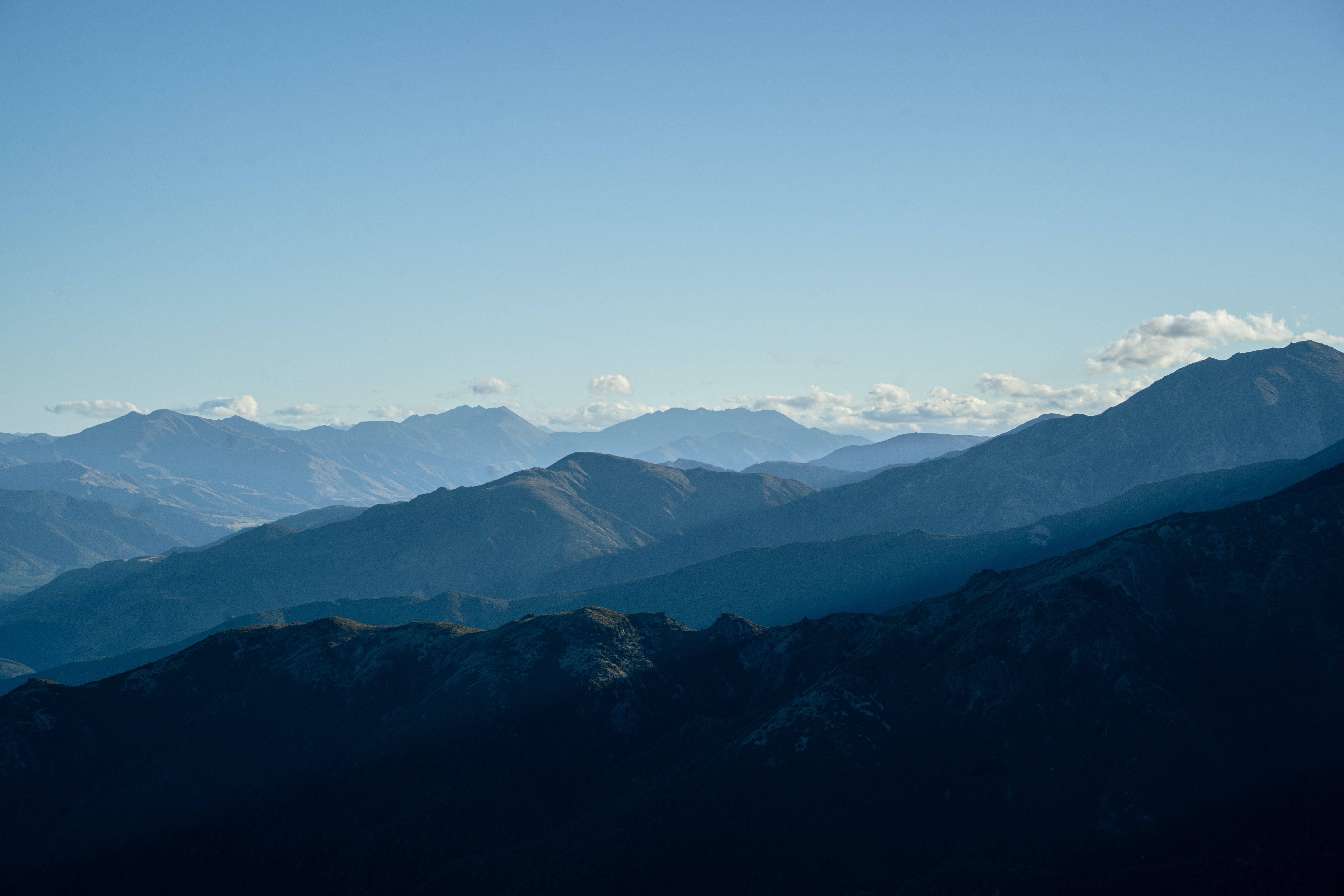 Layered mountain ridges under a blue sky